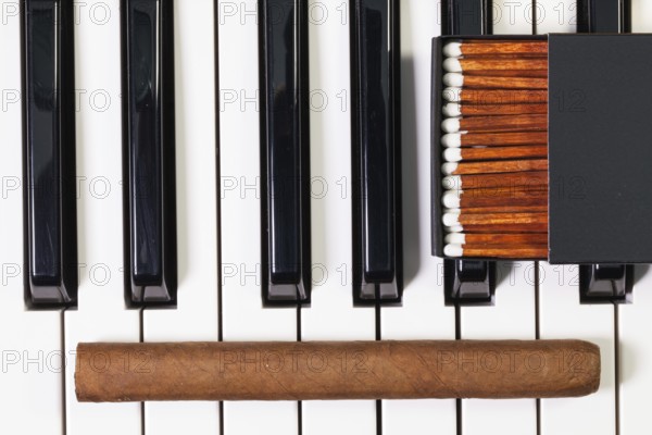 Detail of piano keyboard and luxury cigar