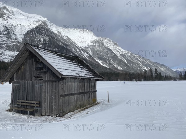 Winter mountains landscape with wooden barn and dramatic sky, Leutasch, Austria