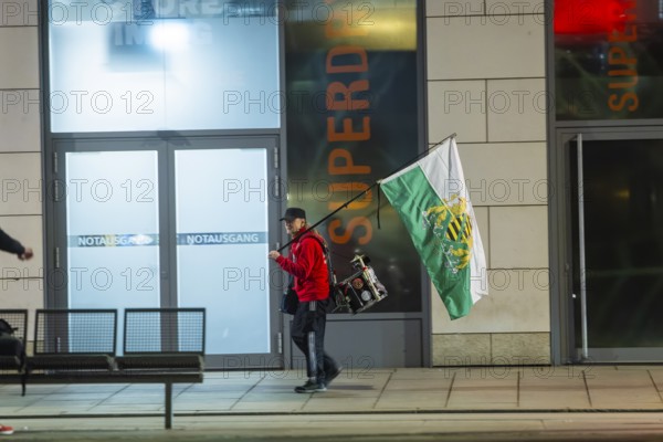 A supporter of the radical Free Saxons, walks with a Saxon flag and drum on Wilsdruffer Straße for the Monday demonstration, Dresden, Saxony, Germany