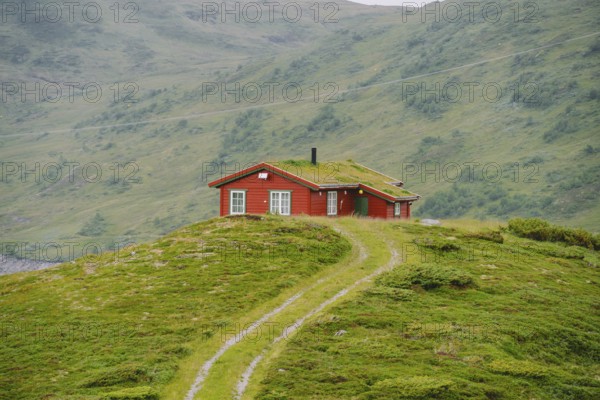 Hut wooden mountain huts in mountain pass Norway. Norwegian landscape with typical scandinavian grass roof houses. Mountain village with small houses and wooden cabins with grass on roof in valley