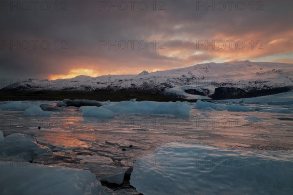 Ice floes on the black sea sand and the coast Fjallsarlon lagoon
