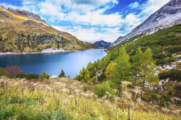 The concept of ecological and extreme tourism. The magic and harmony of the Dolomites. Glacial lake with clear cold water. Mountain Lake Lago di Fedaia, Dolomites