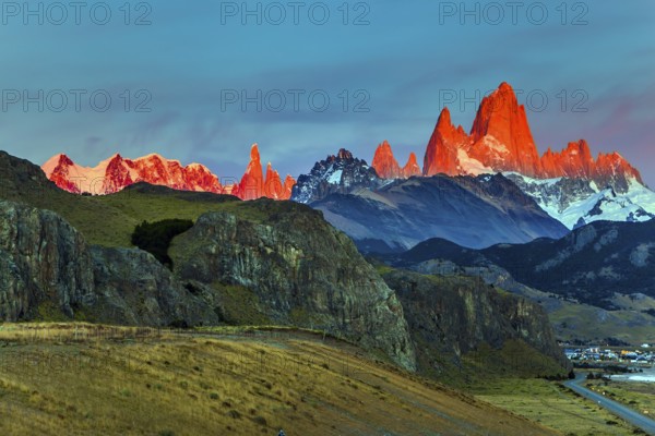 The grand crimson dawn over the mountain range Fitzroy. Mountain peak in Patagonia in the border area between Argentina and Chile. Magnificent and picturesque mountain range, illuminated by the sunrise sun. The concept of extreme, active and photo tourism