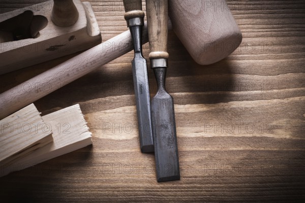 Wooden hammer stud planner flat chisels on wood board construction concept