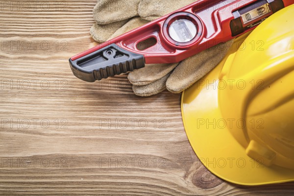 Building helmet protective gloves construction level on wooden board