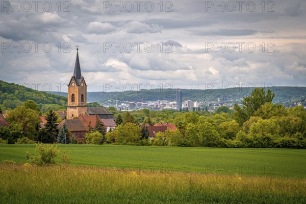 Church of Kunitz in the middle of a rural landscape with a view of the city of Jena, under a cloudy sky, Kunitz, Thuringia, Germany