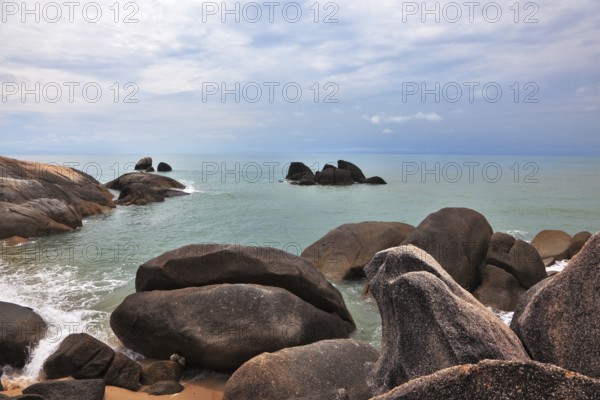 Picturesque coastal cliffs and subdued after a storm sea. Koh Samui
