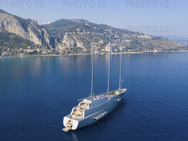 Aerial view 143 metre long three-master Sailing Yacht A, the largest sailing yacht in the world, built to a design by designer Philippe Starck by the German shipyard Nobiskrug and delivered in 2017 to the Russian oligarch Andrei Melnichenko, Andrey Melnichenko, over 100 metre high carbon masts, at anchor off Menton, Cote d'Azur, Mediterranean Sea