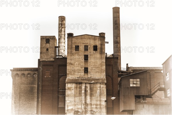 Old power plant building with brick, concrete and metal walls, retro sepia toning