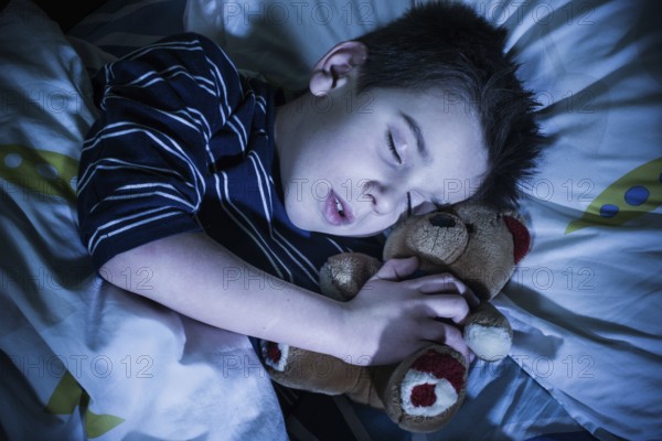 Sleeping child with his toy bear