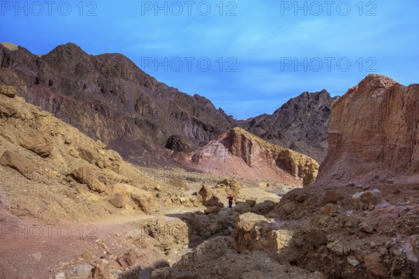 Dry stone desert near the southern seaside resort of Eilat. Woman photographer on a dirt road at the foot of King Solomon