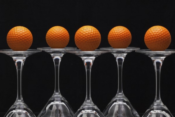 Five glasses of champagne with golf balls