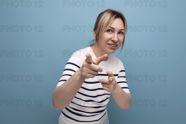 Nahaufnahme einer energetischen blonden jungen frau in einem gestreiften pullover auf einem blauen hintergrund