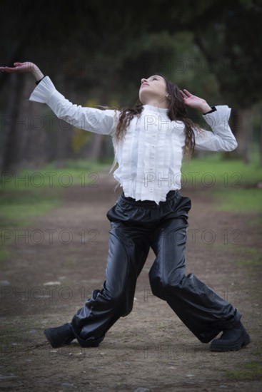 Young woman dancing outdoors. Dance performance in the park