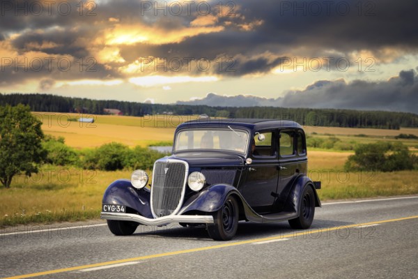 Black Ford Fordor Dillinger Special year 1934 on road on Maisemaruise 2019 car cruise. Edited sky. Vaulammi, Finland. August 3, 2019