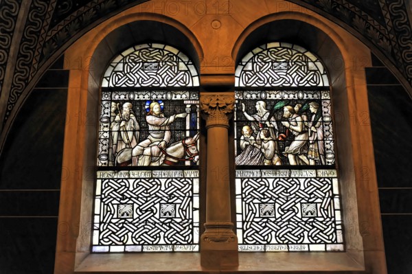 Stained glass window with sacred scenes and filigree stained glass in a church wall, Bad Homburg v. d. Höhe, Hesse, Germany