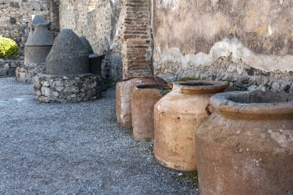 POMPEII, ITALY, MAY 04, 2022, Big clay amphoras buried into the soil of an ancient Pompeian warehouse, Southern Italy