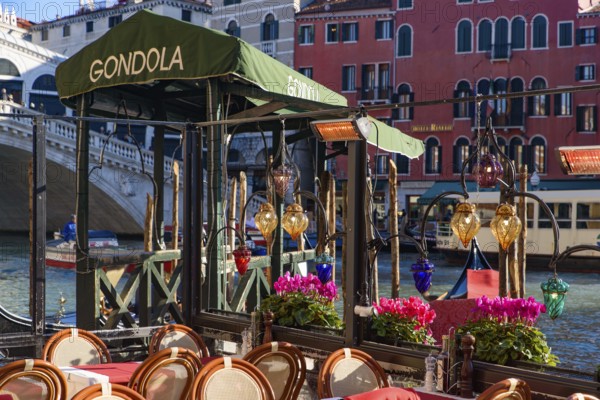 View of the Grand Canal, Rialto Bridge, and gondolas from outdoor restaurant seats, Venice, Italy