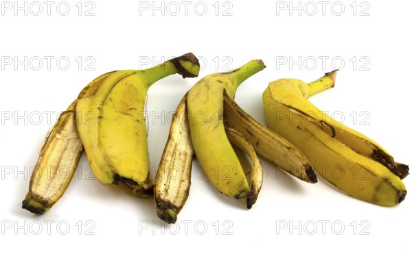 Three peels from bananas that begin to rot. Organic fruit waste isolated on white background