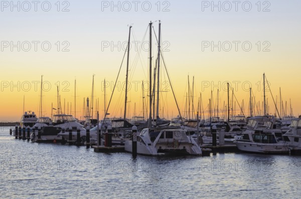 Sunset over the Hillarys marina full of mooring boats, Perth, WA, Australia