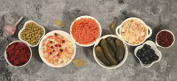 Fermented products on a concrete table, food background, advertising banner, healthy food concept, sauerkraut, kimchi, pickled beets, cucumbers, peas, olives, natural products for weight loss, top view, selective focus