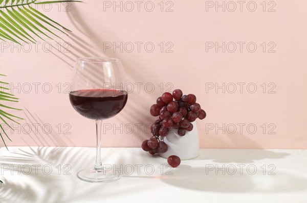Modern still life with red wine, margarita alcoholic cocktail and grapes on a pastel background with long hard shadows, minimal concept for a bar, cafe, advertising banner, selective focus, space for text