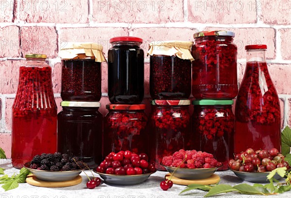 Jars with raspberry, cherry, gooseberry jam and compote on kitchen background with leaves and fresh berries, home canning concept, banner and advertisement of shop and market, village harvest, selective focus