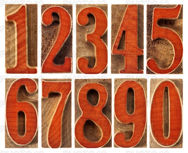 A set of isolated ten numbers from zero to nine in letterpress wood type printing blocks stained by red ink