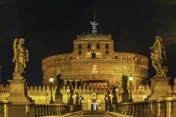 View of angel sculpture on Ponte Sant'Angelo and Castle of the Holy Angel, Rome. Evening