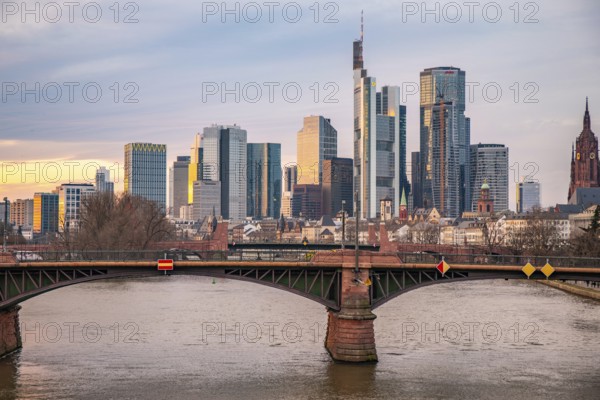 A big city in the evening at sunset. Modern buildings in a skyline by the river. Skyscrapers are reflected in the water. Modern architecture of the metropolis Frankfurt am Main, Germany