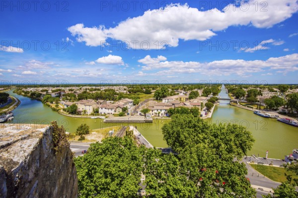 Shipping channel flows into the Mediterranean Sea. Antique walls of the medieval port city of Aigues-Mortes. Yachts moored off the coast. France. The concept of historical and photo tourism