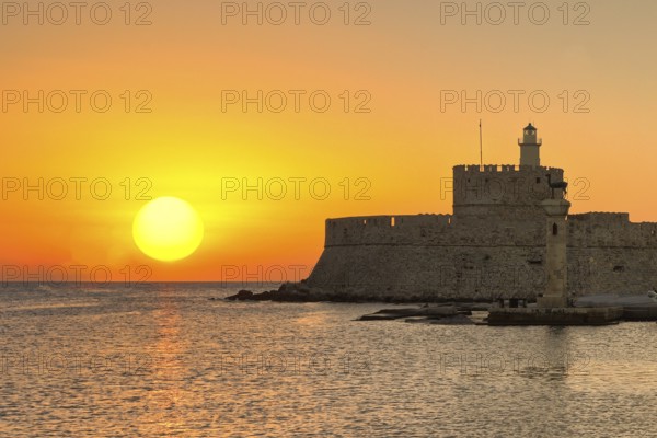 The sunrise at the entrance with the deers of the old port of Rhodes, Greece