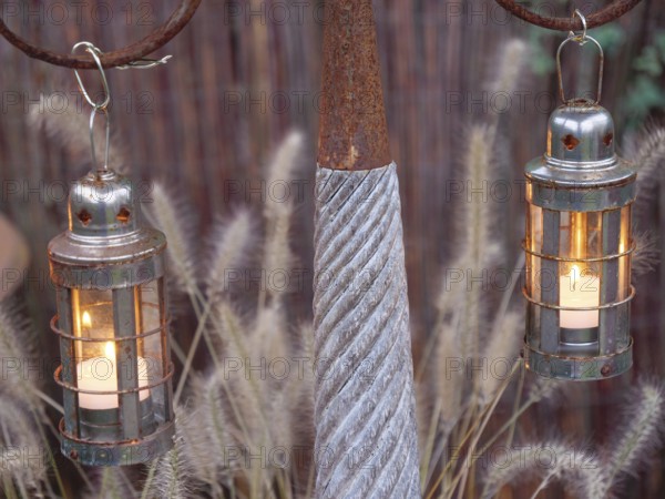 Rustic metal lanterns with burning candles that provide a warm source of light, weseke, münsterland, germany
