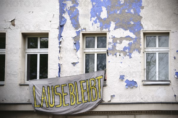 A sheet with a slogan hangs in front of a squatted flat in an old building in Berlin Kreuzberg