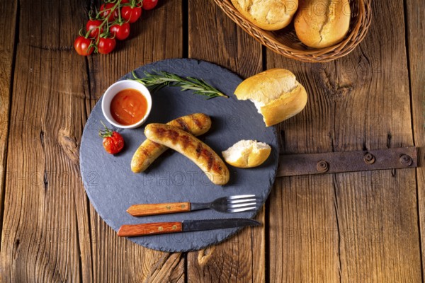 Rustic bratwurst with ketchup and fresh rolls