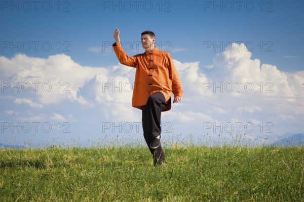 A man doing Qi-Gong in the green nature