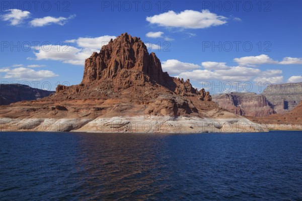 Scenic huge artificial pond Powell on the Colorado River, USA. The lake is surrounded by picturesque banks of orange sandstone. Walk around the lake Powell at sunset