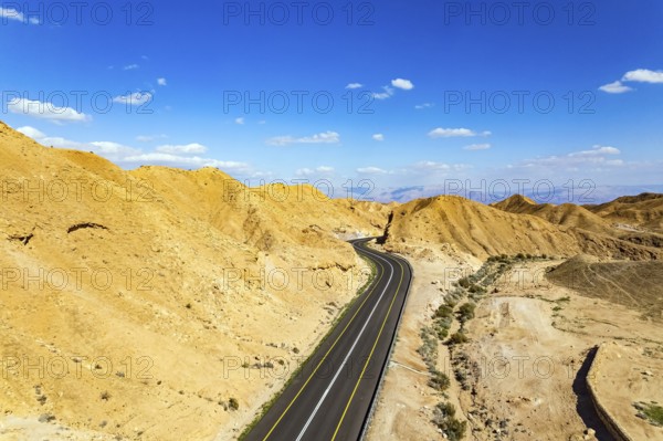 Israel. Desert on the shores of the Dead Sea. Asphalt highway meanders among the hills. Dead Sea mud has healing properties. Bird's eye view