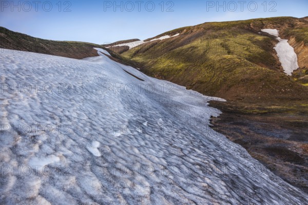 Summer morning in the National Park Landmannalaugar, Iceland. Big unmelted in July snowfield