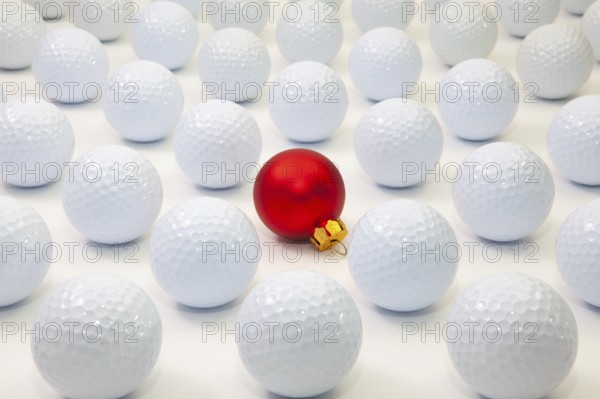 Pattern with white golf balls and red Christmas decoration on the table
