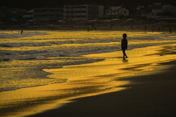Children playing in the twilight of the beach. Shooting Location: Kamakura, Kanagawa Prefecture