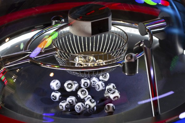 Black and white lottery balls in a rotating bingo machine. Lottery balls in a sphere in motion. Gambling machine and euqipment. Blurred lottery balls in a lotto machine. Number 16
