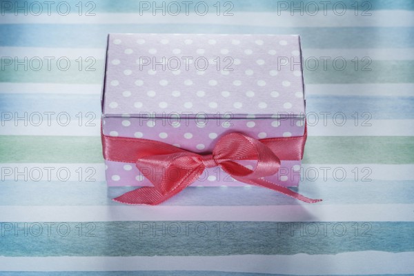 Pink present box on blue striped fabric top view holidays concept