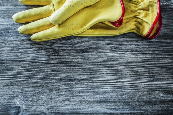 Leather safety gloves on wooden board