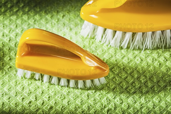 Set of new plastic brushes on green dishcloth