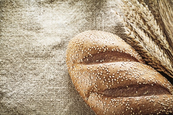 Wheat ears bread on burlap background