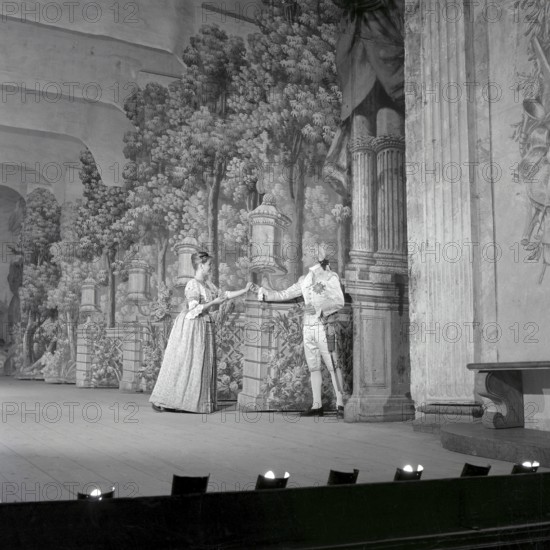 As if in the 18th century. Actors Jarl Kulle and Maj-Britt Nilsson in a scene taken inside the royal castle Drottningholm in Stockholm. The photograph was originally published to illustrate a historic novel running in several episodes in a magazine 1956. The room, furniture and clothing are typical of the 18th century Sweden. Conard ref EC3168