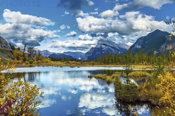 Lush cumulus clouds are reflected in the smooth water of the lake. Warm autumn day on the lake Vermilion. The concept of ecological, photographic and active tourism