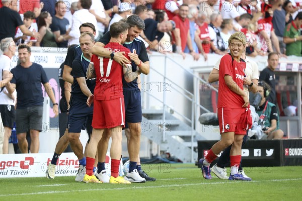 Assistant coach Florian Bruns (SC Freiburg) hugs the two-time goalscorer, goalscorer #f17, Ritsu Doan (SC Freiburg) is happy after the match of the 1st FBL: 24-25: 1. Sptg. SC Freiburg - VfB Stuttgart DFL REGULATES PROHIBIT ANY USE OF PHOTOGRAPHS AS IMAGE SEQUENCES AND/OR QUASI-VIDEONan Photo: Joachim Hahne/johapress, Freiburg, Germany / Germany