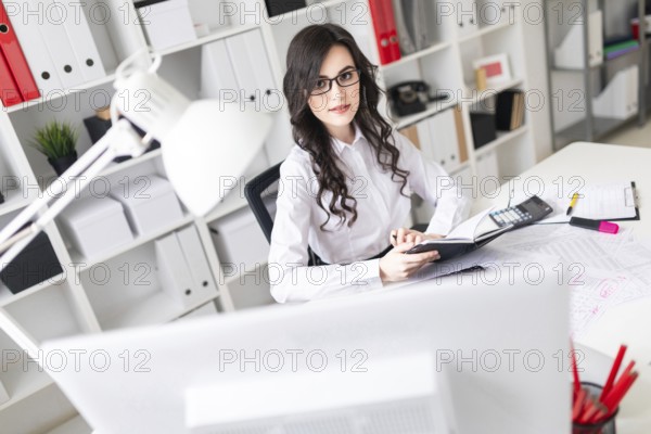 A charming young girl is working in a bright office. photo with depth of field